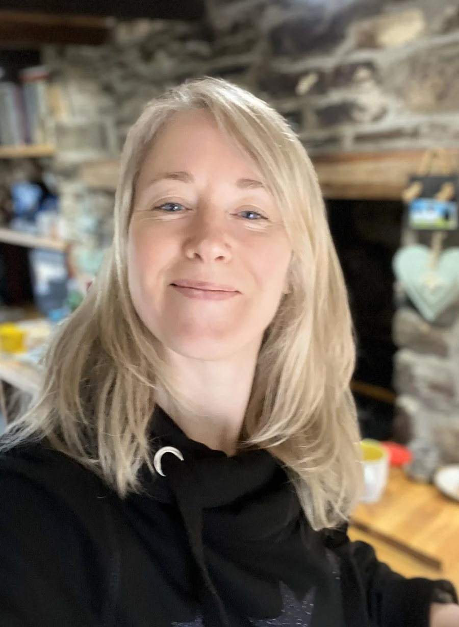 Melanie Phillips sitting in a cozy cottage living room.