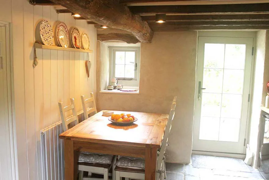 The newly installed solid wood back door in the cottage kitchen, painted French Grey.