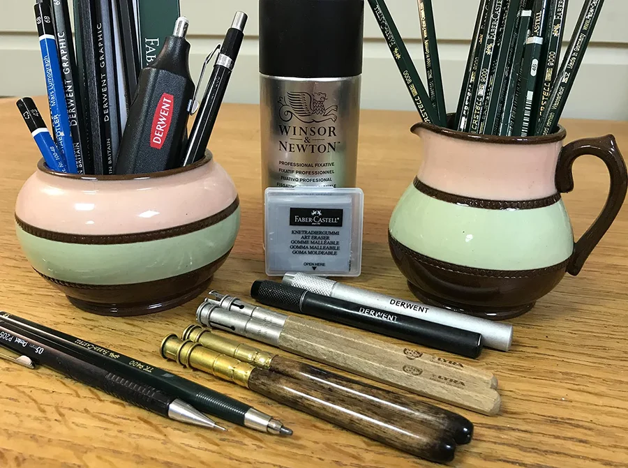 Assortment of Melanie's drawing tools including pencil extenders, erasers, and mechanical pencils.