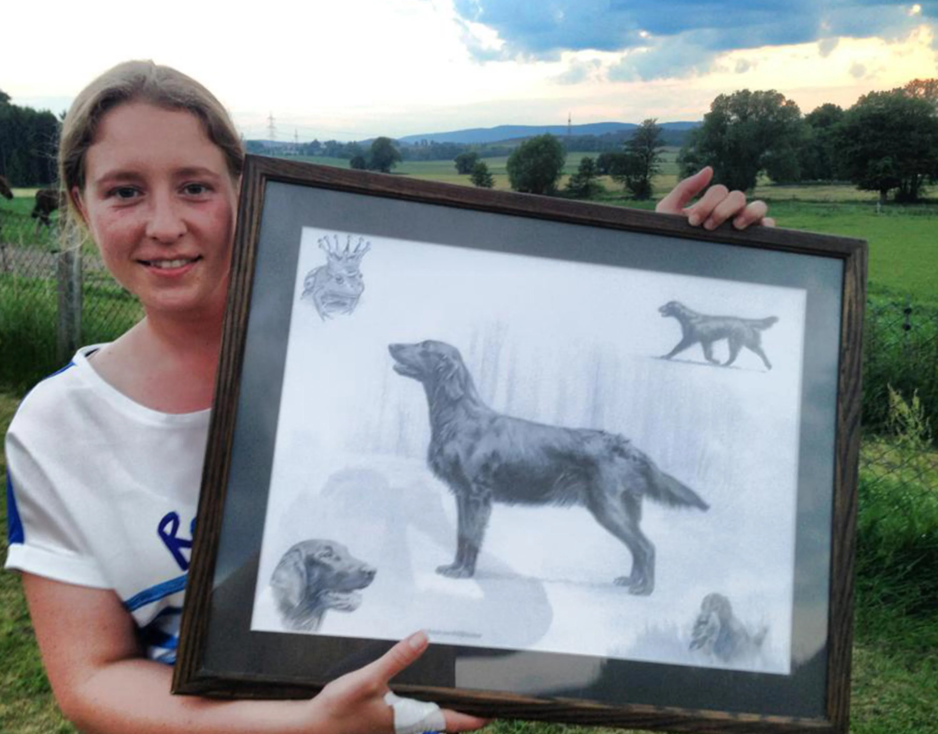 Happy client Anna holding her custom pencil portrait of Fritzie vom Wildförstersee (Frog), a Flat Coated Retriever.
